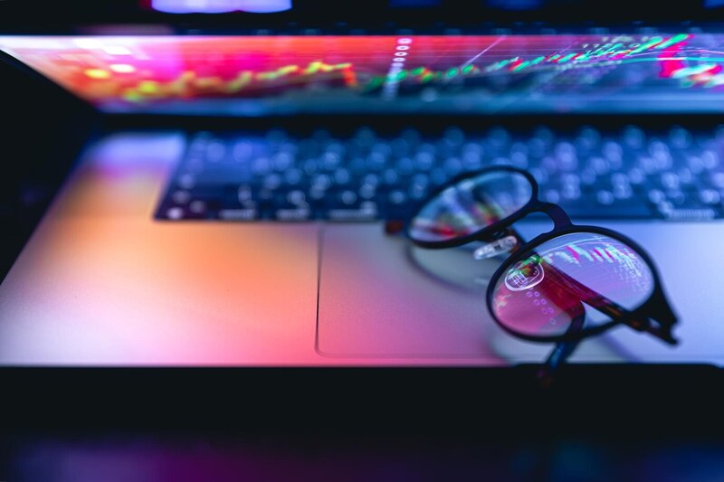 A pair of glasses resting on a laptop screen, symbolizing work or study.