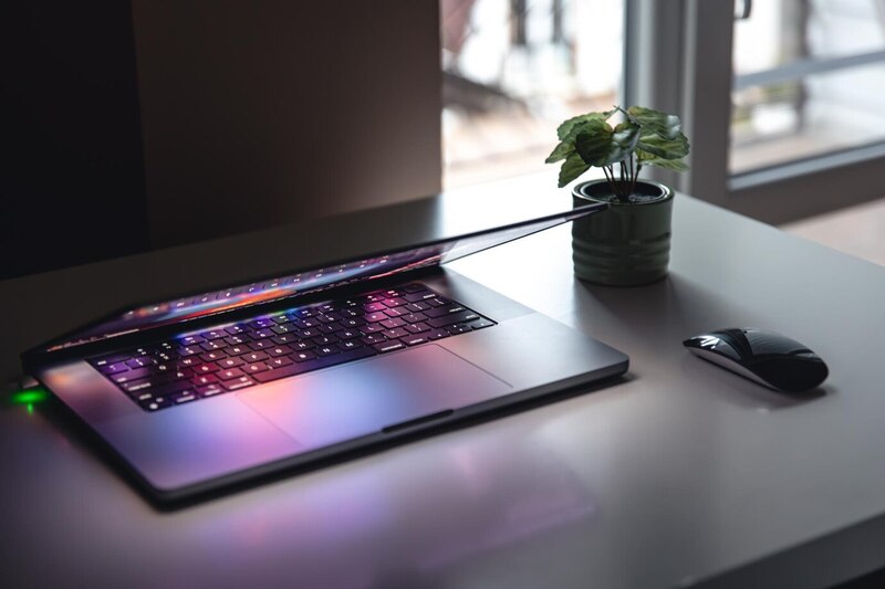 A laptop with vibrant lights on a desk.